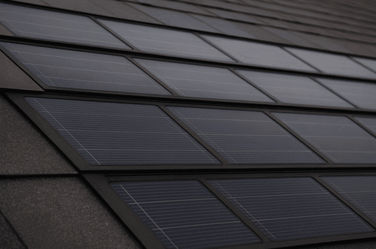 Close-up of sleek, low-profile solar roofing shingles integrated into an asphalt roof, showing smooth photovoltaic panels under natural daylight.