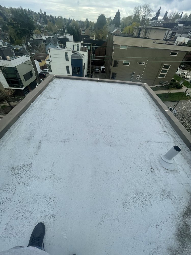 Modern gray deck and composite pavers installed by Orca Roofing & Exteriors.

