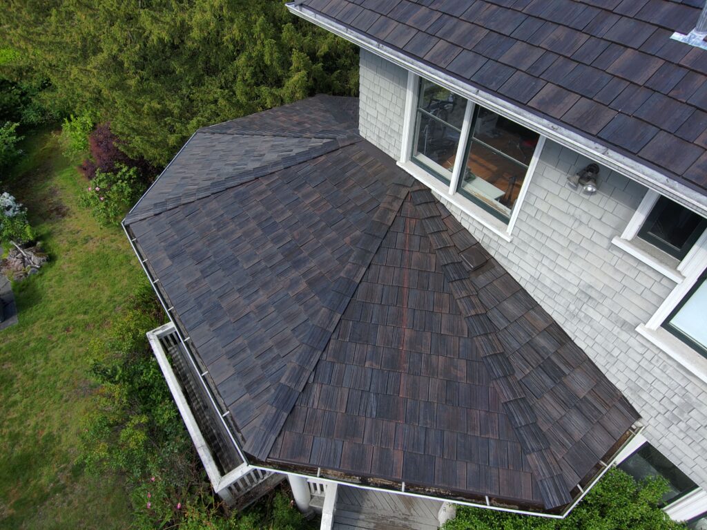Roofer installing new underlayment on a steep roof in Rosedale